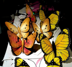A collection of hand-painted paper butterflies in various colors, including yellow and pink, with detailed designs and accessories for hanging.